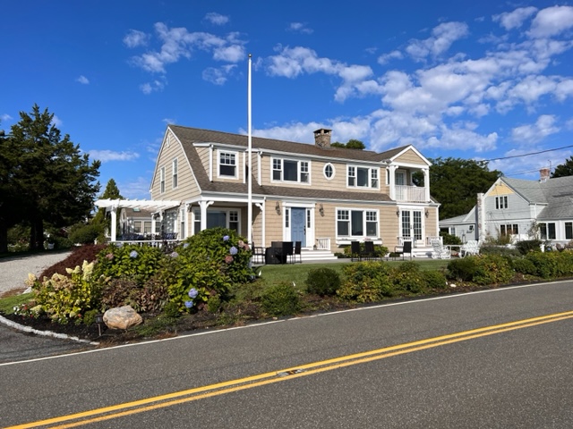 A house with a large lawn and a road.