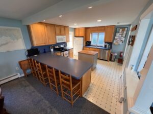 A kitchen with wooden cabinets and tile floors.