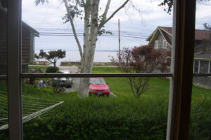 A red car is parked in the grass.