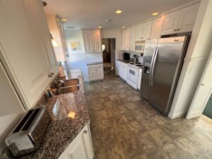 A kitchen with granite counter tops and white cabinets.