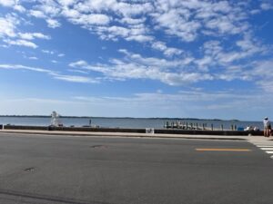 A road with water and clouds in the background.