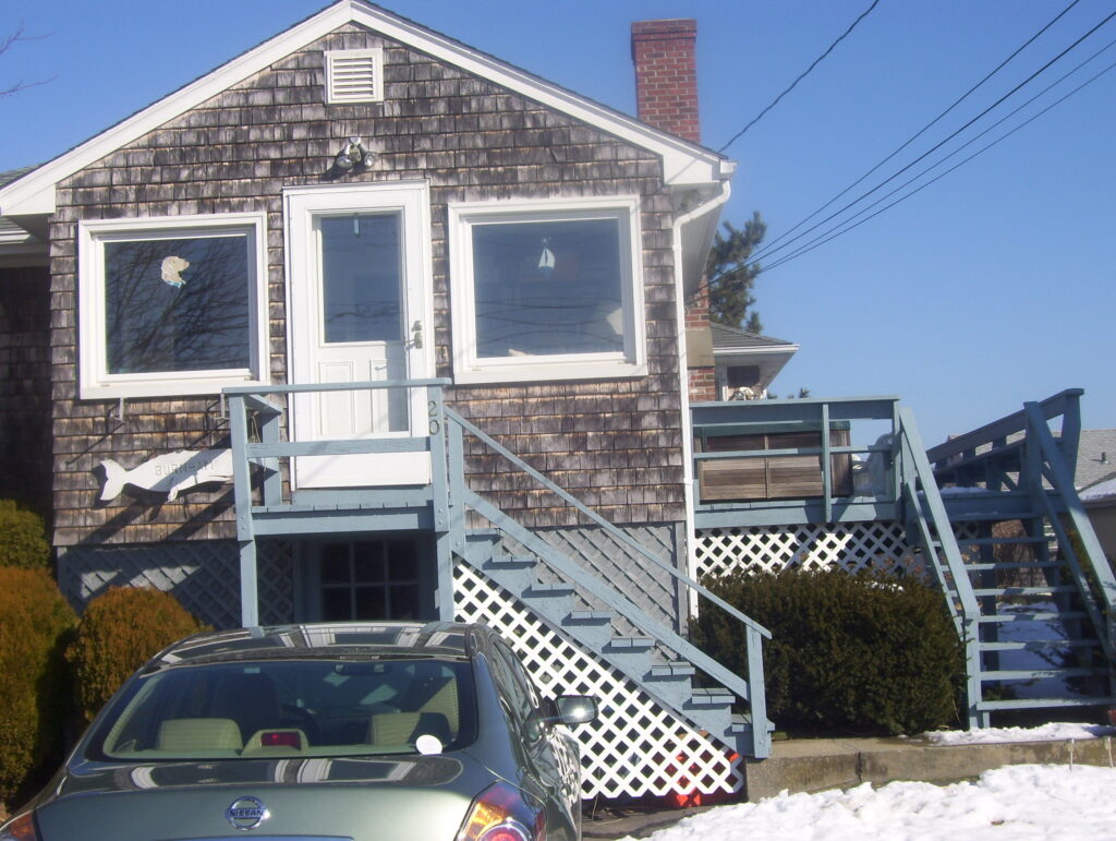 A car parked in front of a house with stairs.