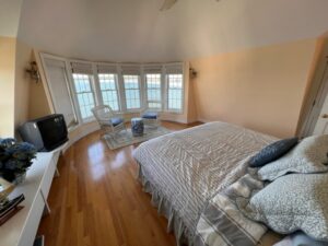 A bedroom with a bed, tv and chair in it.