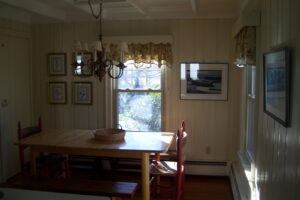 A dining room table and chairs in front of the window.