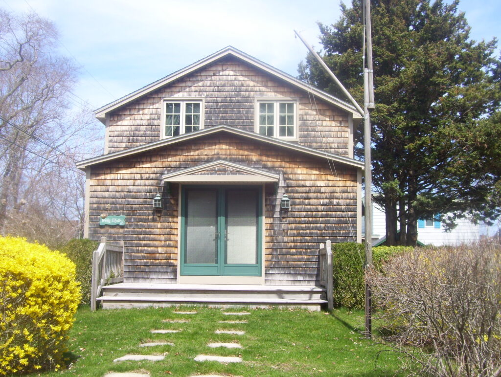 A house with green doors and steps in front of it.