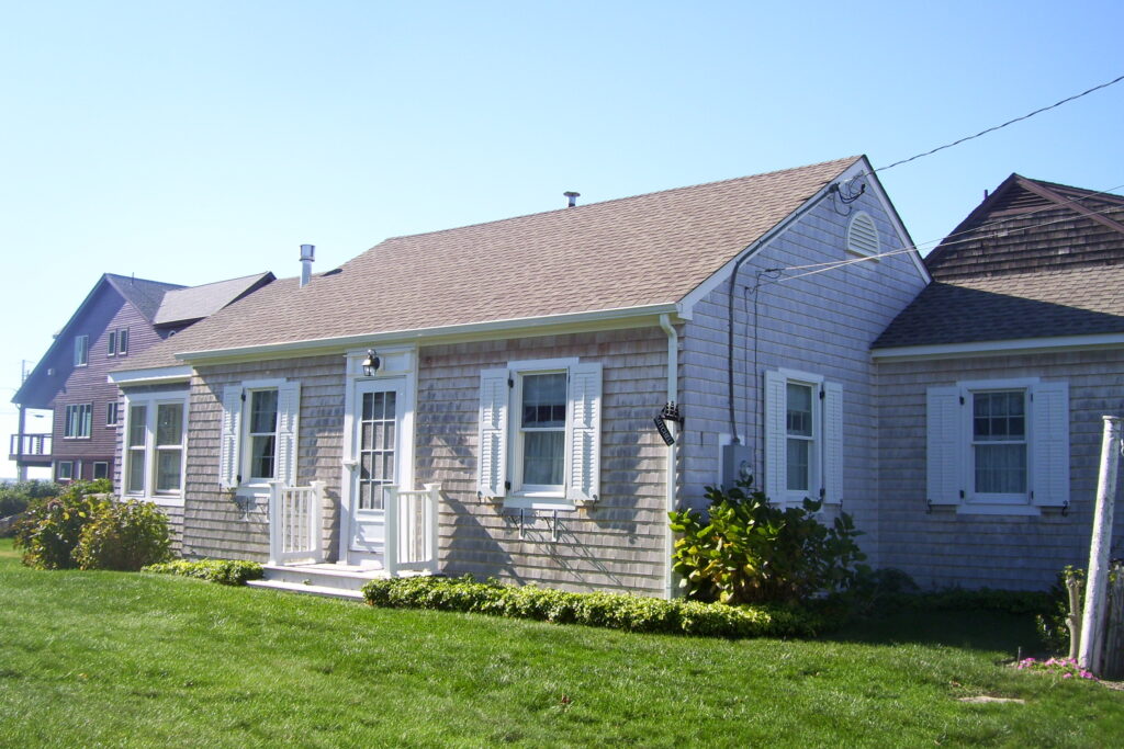 A house with a green lawn and white shutters.