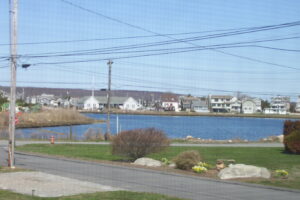 A view of houses and water from the road.