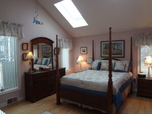 A bedroom with a bed, dresser and mirror.