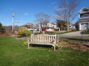 A wooden bench in the middle of a green field.