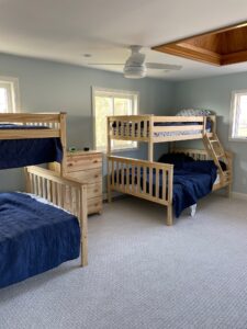 A room with bunk beds and two tables.