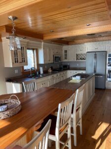 A kitchen with wooden floors and white cabinets.