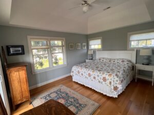 A bedroom with a bed, dresser and window.