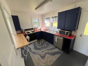 A kitchen with blue cabinets and black counters.