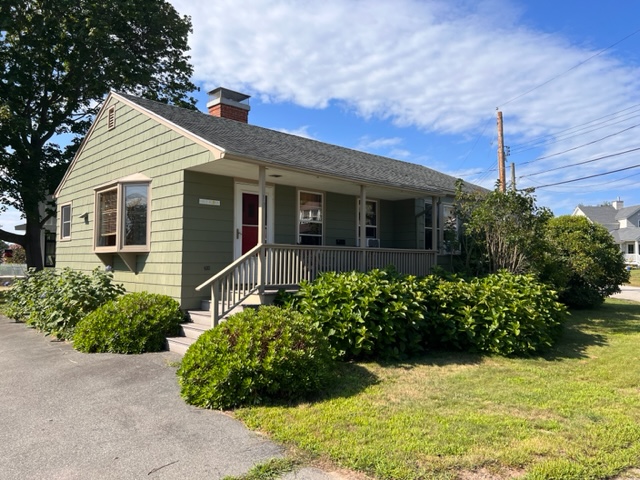 A house with bushes and trees in front of it