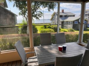 A table and chairs in front of the water.