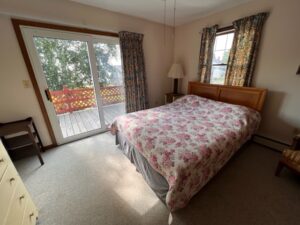 A bedroom with a bed and a balcony