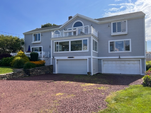 A large house with two garage doors and a driveway.