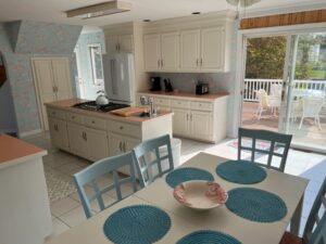 A kitchen with white cabinets and blue chairs