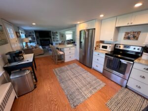 A kitchen with stainless steel appliances and wooden floors.