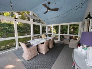 A covered patio with chairs and table in it