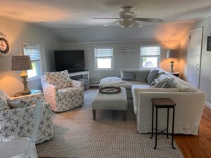 A living room with white furniture and a flat screen tv.