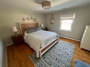 A bedroom with a bed, nightstand and lamp.