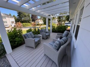 A patio with furniture and plants on the deck.