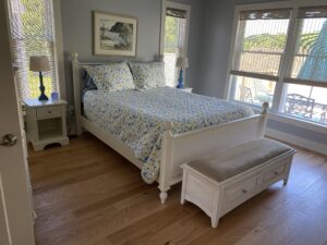 A bedroom with a bed, nightstand and window.