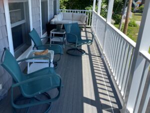 A porch with chairs and tables on it