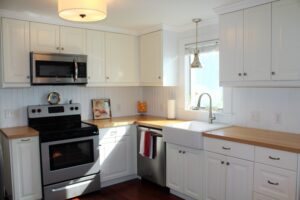 A kitchen with white cabinets and stainless steel appliances.