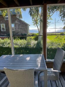 A table and chairs on the patio of an outside house.