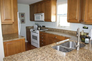 A kitchen with wooden cabinets and granite counter tops.