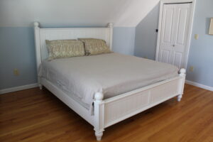 A bed with white wooden frame and headboard.