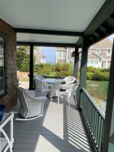 A porch with chairs and tables on it