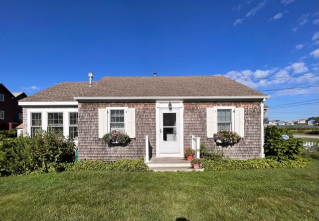 A house with a dog sitting in front of it.