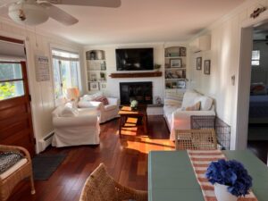 A living room with wood floors and white furniture.