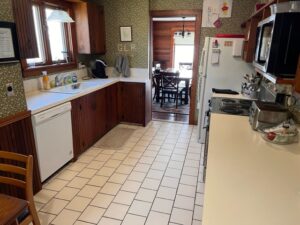 A kitchen with white tile floors and brown cabinets.