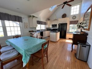 A dining room table and chairs in the middle of a kitchen.