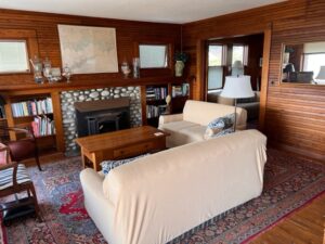 A living room with wood paneled walls and fireplace.