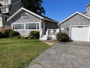 A house with a driveway and garage in front of it.